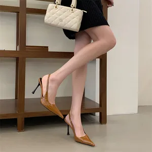 Elegant brown patent leather pointed toe slingback high heel pumps shown on a model