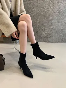 Elegantes botines negros de gamuza con punta fina y tacón de aguja en vista de estilo