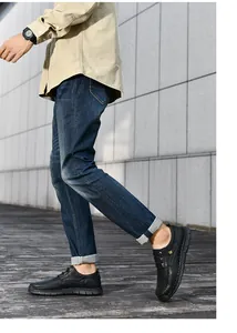 Close-up van zwarte heren casual schoenen van zacht leer die buiten op een houten dek lopen