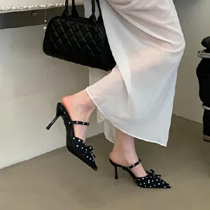 Elegant black polka dot stiletto mules with bow detail and pointed toe