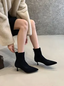 Detalle de botines de calcetín de ante negro con punta afilada y tacón bajo en modelo