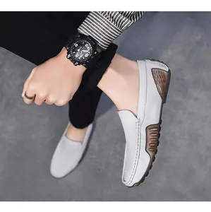 Vista detallada de mocasines de cuero gris para hombre con suela blanda usados por el modelo