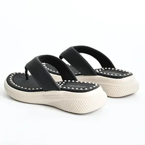 Detail view of women's black platform flip-flops with massage footbed and thick sole