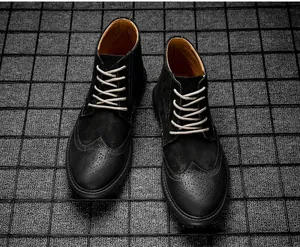 Bovenaanzicht detail van zwarte halfhoge brogue-laarzen met beige veters en textuur