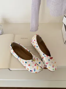 Detail view of white split-toe tabi flats with colorful polka dots and bow accent