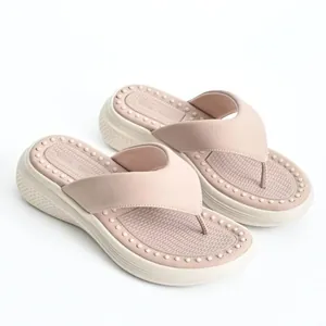 Close-up of pink platform flip-flops showing the textured massage footbed design