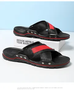 Detailopname van zwarte leren herensandalen met rode bandjes en klinknagels