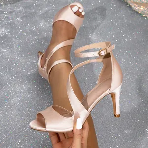 Elegant nude satin high heel sandals with peep toe and ankle strap for women.