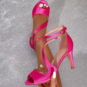 Hot pink satin peep toe high heel sandals with ankle straps and a glittery background.