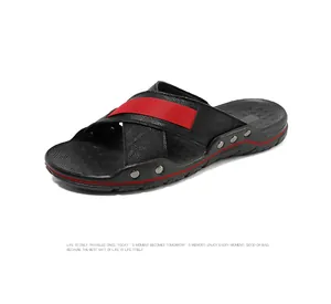 Gedetailleerd beeld van zwarte leren herensandalen met rode streep en zilveren klinknagels