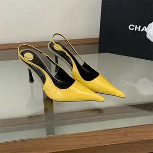 Close-up of elegant yellow patent leather pointed-toe slingback heels on glass surface