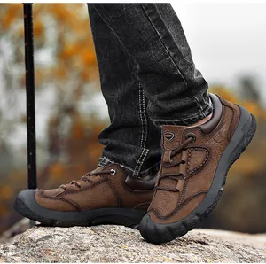 Primo piano di scarpe da trekking in pelle marrone da uomo su rocce all'aperto
