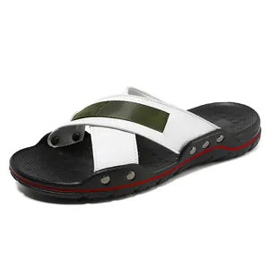 Leren heren strandsandalen met kruisbandjes en klinknageldetails op witte achtergrond