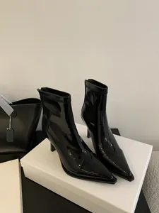 Detailaufnahme glänzender schwarzer Lackleder-Stiefeletten mit spitzer Zehenpartie