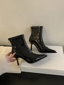 Nahaufnahme von schwarzen Lackleder-Stiefeletten mit spitzer Zehenpartie