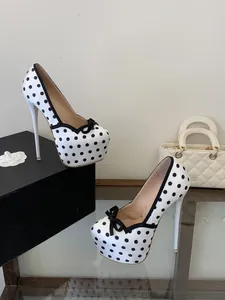 Primer plano de elegantes tacones de plataforma con lunares blancos y negros y lazo