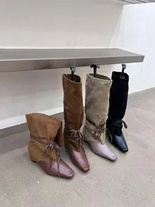 Détail rapproché de bottes de cow-boy rétro bicolores en plusieurs coloris tendance