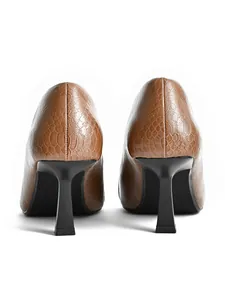Close-up of brown crocodile pattern pumps featuring a stylish wine glass heel.