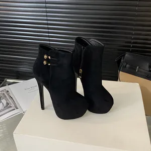 Detalle de botines sexys de ante negro con tacón de 16cm y hebilla dorada de moda