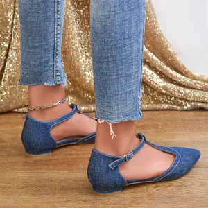 Close-up of elegant denim T-strap pointed flats worn with jeans for a casual chic look.