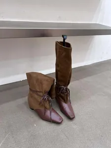 Détail de bottes souples bicolores rétro avec textures daim et cuir