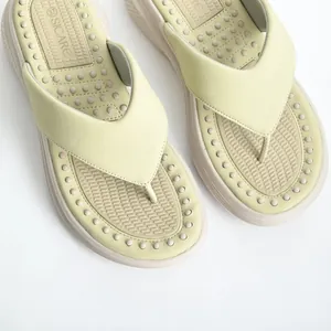 Detail shot of light green platform flip-flops featuring a textured massage footbed.