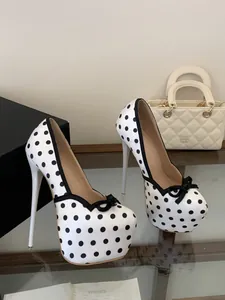 Detalle de zapatos de tacón alto con plataforma y lunares blancos con lazo