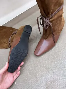 Vue détaillée des bottes patchwork marron vintage montrant la texture du cuir et la semelle