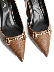 Detail shot of brown crocodile texture pointed toe pumps with gold horsebit buckle
