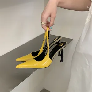 Close-up of bright yellow patent leather pointed-toe slingback high heels.