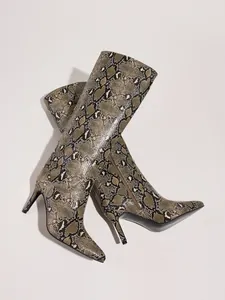 Detailed view of fashionable snakeskin print knee-high boots with stiletto heels.