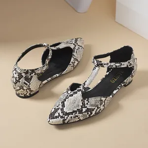 Close-up detail of elegant T-strap flat shoes featuring a stylish snakeskin pattern design