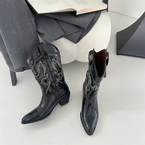 Hochwertige Nahaufnahme schwarzer Westernstiefel mit aufwendiger weißer Stickerei
