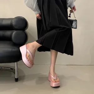 Detailed view of pink platform wedge flip-flops with high-shine finish for women