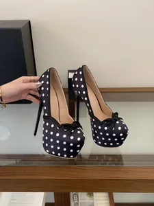 Elegantes tacones de plataforma con lunares blancos y negros y detalle de lazo