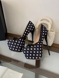 Primer plano de zapatos de tacón de aguja con lunares negros y detalle de lazo