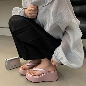 Stylish pink platform wedge flip-flops with thick soles for women, perfect for summer.