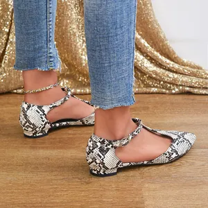 Close-up of elegant snakeskin pattern T-strap flat shoes for women in a stylish setting