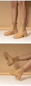 Detailed view of beige platform Chelsea boots with knit ankle cuffs and chunky heels.