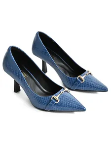 Detailed view of blue crocodile embossed pointed-toe pumps with gold metal buckle