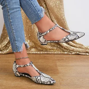 Close-up view of elegant snakeskin pattern T-strap flat shoes with a pointed toe design.
