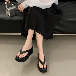 Stylish black platform wedge flip-flops for women shown in a summer fashion scene