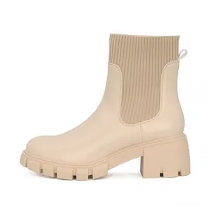 Side profile of beige Chelsea ankle boots with chunky heels and knitted ribbing details