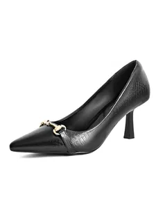 Close-up of black crocodile-embossed high heels with gold horsebit buckle detail