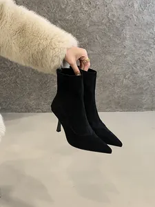 Close-up of elegant black suede pointed-toe ankle boots with slim high heels and zipper