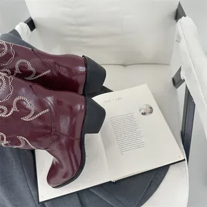 Detailansicht burgunderrote Vintage-Cowboystiefel mit weißer Herzstickerei im Detail