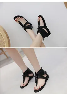 Macro detail view of black high-top flat thong gladiator sandals with metallic buckles