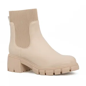 Professional side view of a beige Chelsea boot with a chunky lug sole and knitted shaft