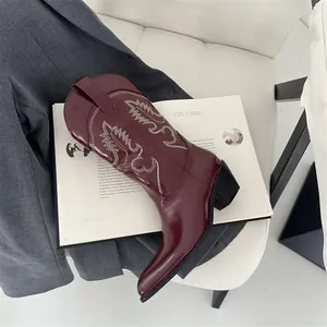 Nahaufnahme der burgunderroten Vintage-Cowboystiefel mit eleganten weißen Stickereien