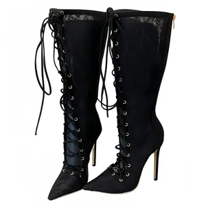 Detail of black lace mesh high heel boots with stiletto gold heels and lace-up front.